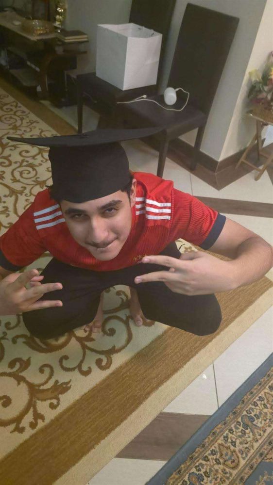 A graduate crouching in a mortarboard